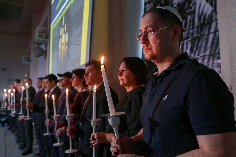 People take part in a memorial ceremony for Holocaust victims