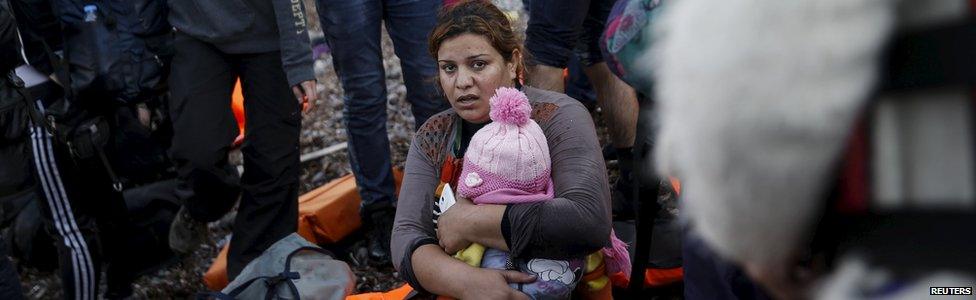 Migrant holding a child on Greek island of Lesbos, 10 November 2015