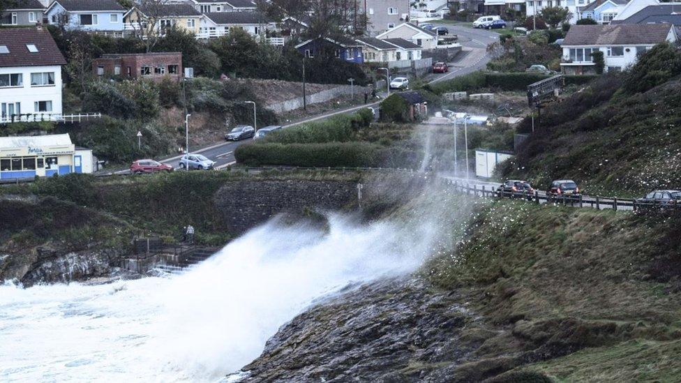 Waves crash over the road at Mumbles, Swansea Bay