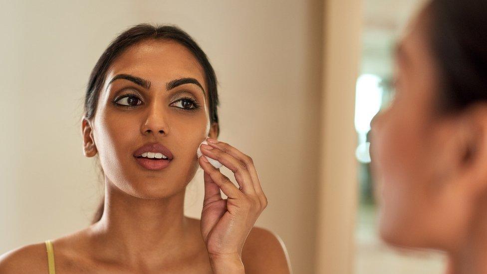 A woman removing makeup