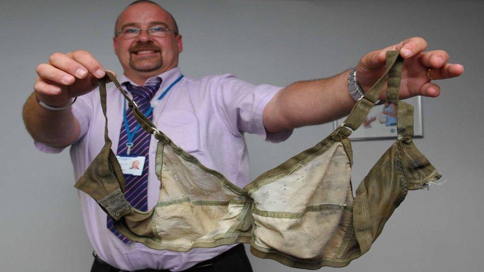 A man holding a bra.