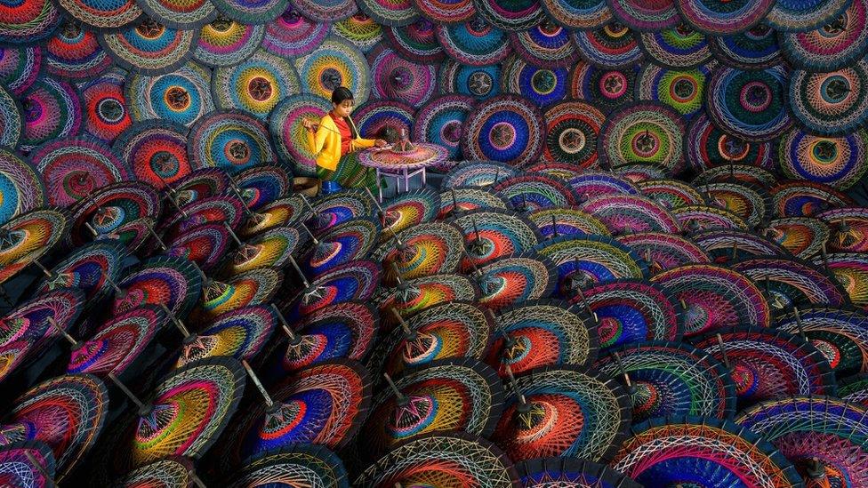 This woman is seen making parasols in a workshop in Mandalay, Myanmar.