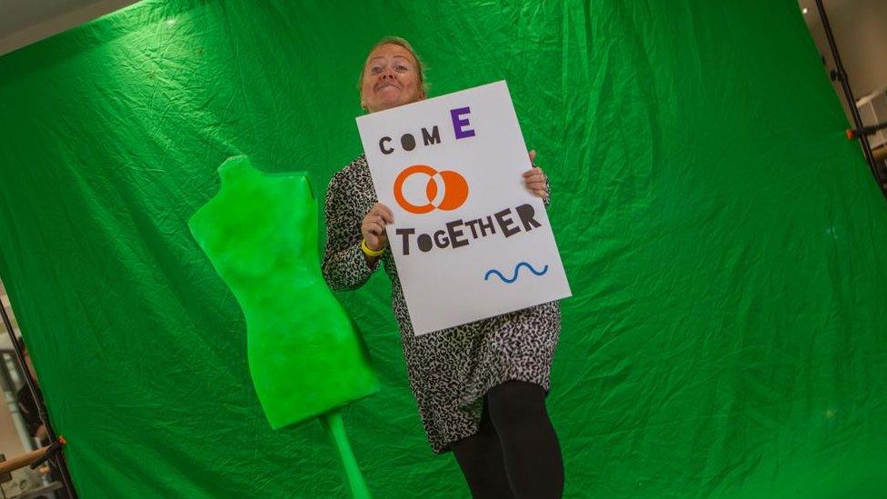 A woman dancing in front of a green screen