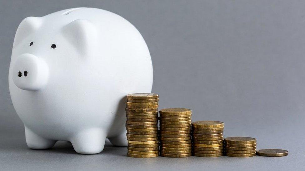 White ceramic piggy bank over a grey background