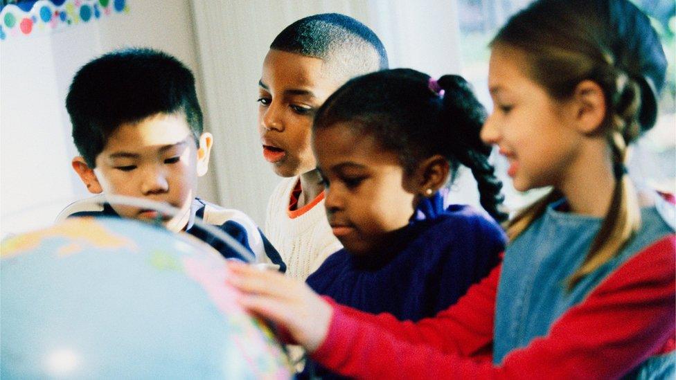 Children looking at a globe