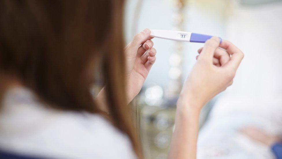 woman holding pregnancy test