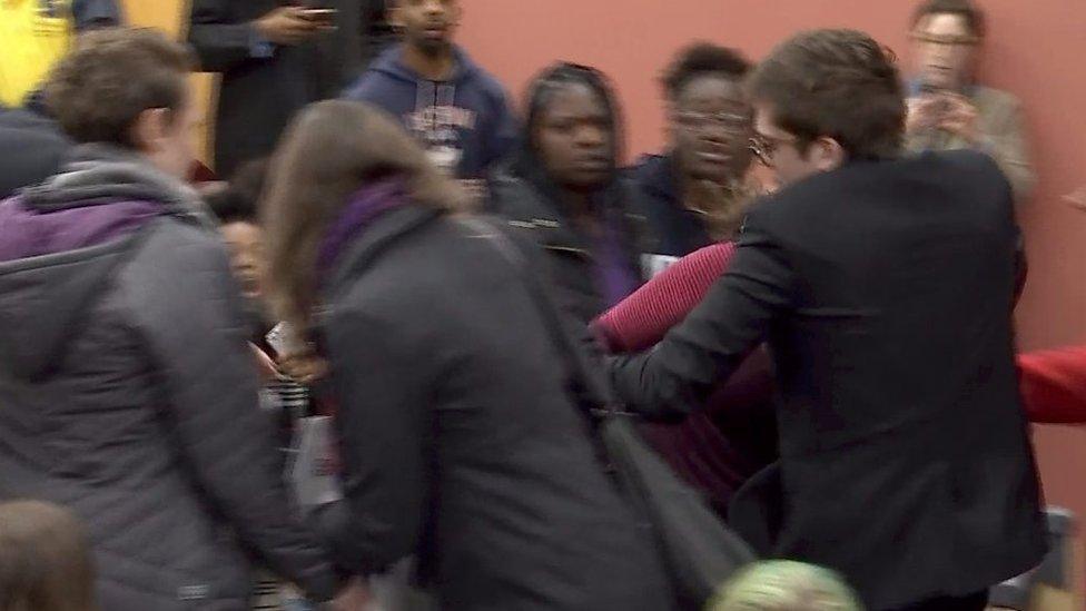 Lucian Wintrich grabs speech attendee after she walks away with his speech.