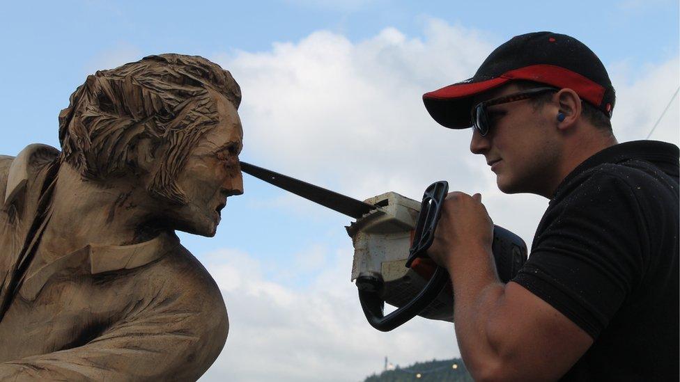 Cerflun o bren o'r chwaraewr rygbi Gareth Edwards yn cael ei greu gan Edward Parkes // A wood sculpture of Gareth Edwards being created by Edward Parkes with his chainsaw