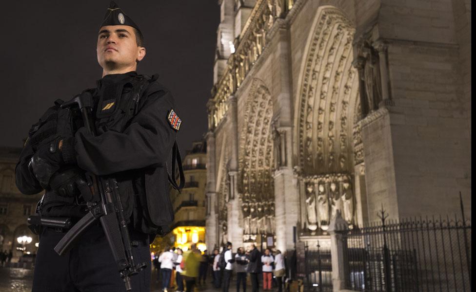 A gendarme standing in front of the Notre Dame