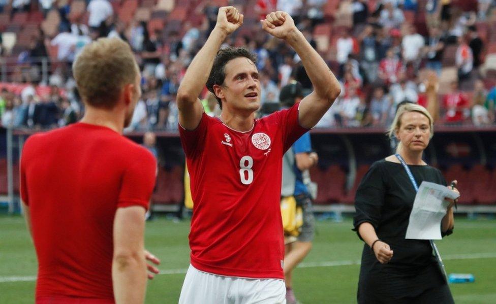 Danish international footballer Thomas Delaney raises his fists above his head in celebration