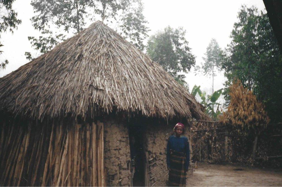 Peter's mother stands outside the house where he grew up