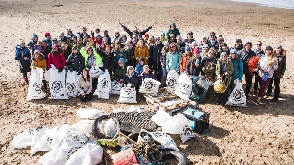 A group of volunteers cleaning up a beach in Cornwall for Surfers Against Sewage