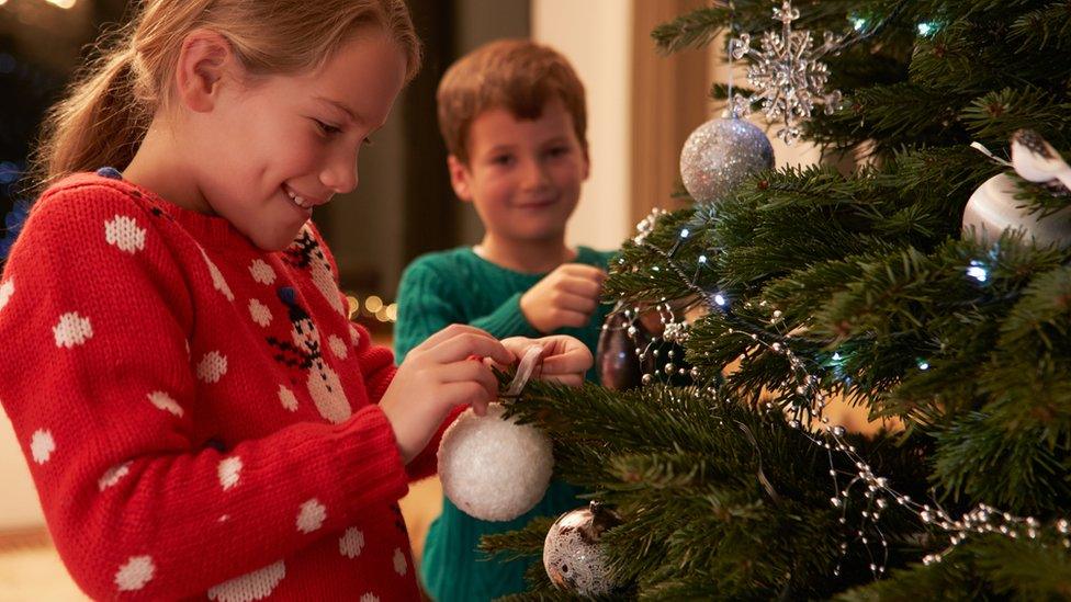 Children decorating a Christmas tree