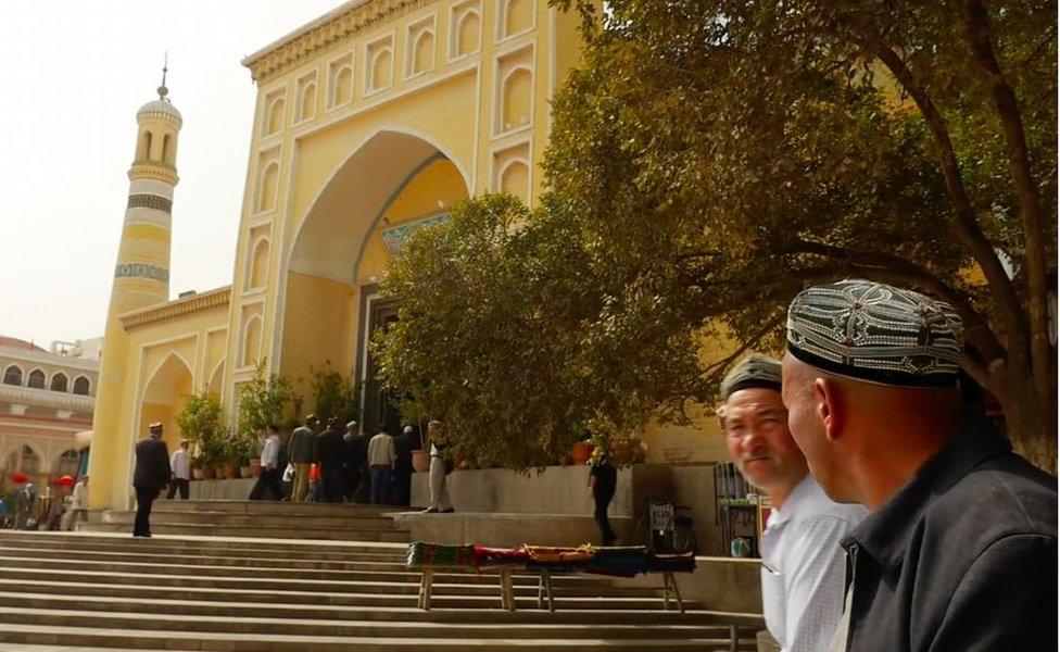 The Id Kah mosque, with worshippers passing by