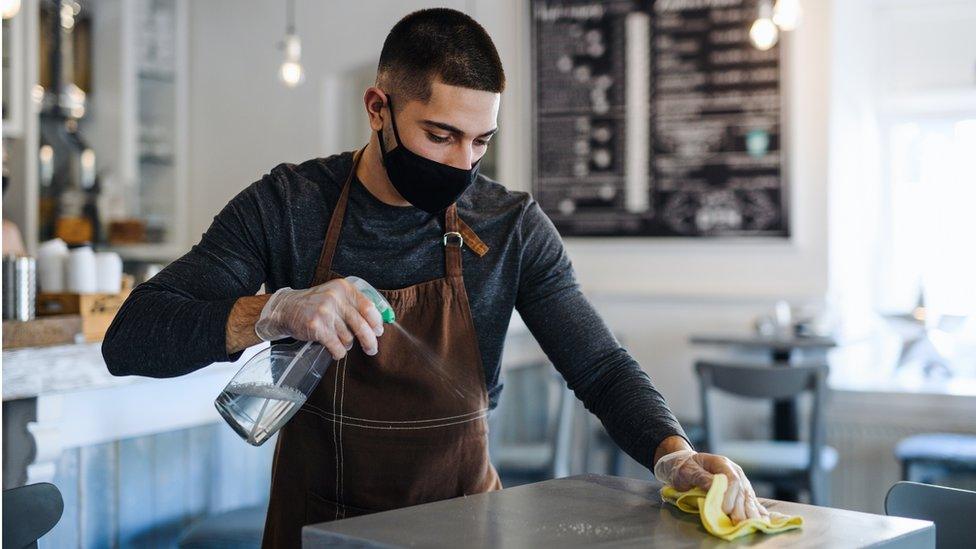 Waiter cleans table