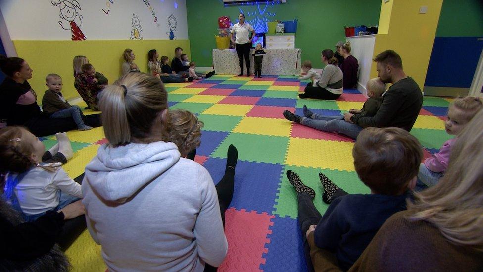 Children and parents sit in a circle