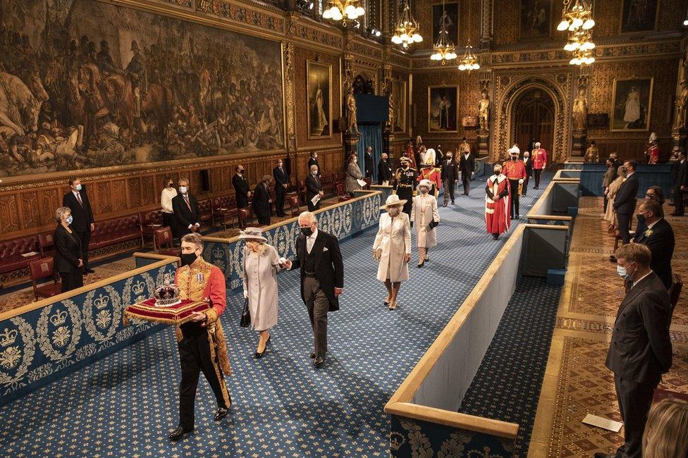 Queen Elizabeth II, accompanied by the Prince of Wales, proceeds through the Royal Gallery before delivering the Queen"s Speech during the State Opening of Parliament in the House of Lords at the Palace of Westminster in London