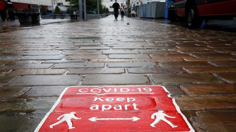 Covid social distancing sign in Blackburn cobbled street