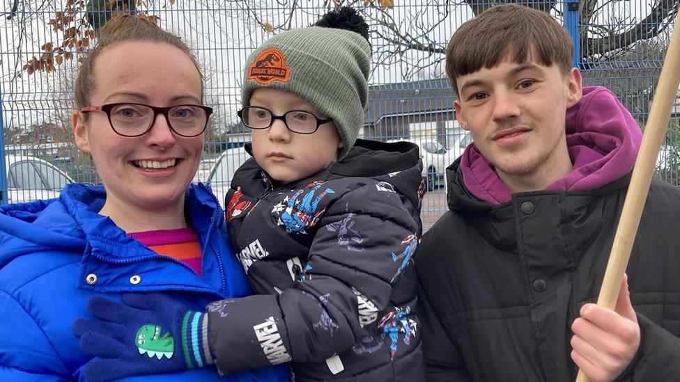 Maria Rogan, with her child, and Eamon McQuillan, two classroom assistants on strike outside St John the Baptist Primary School in west Belfast