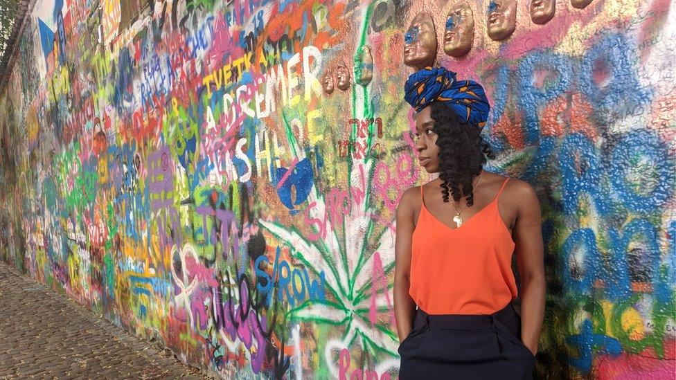 Liz Ogbonna-Godfrey stands next to a mural in Prague, Czech Republic.