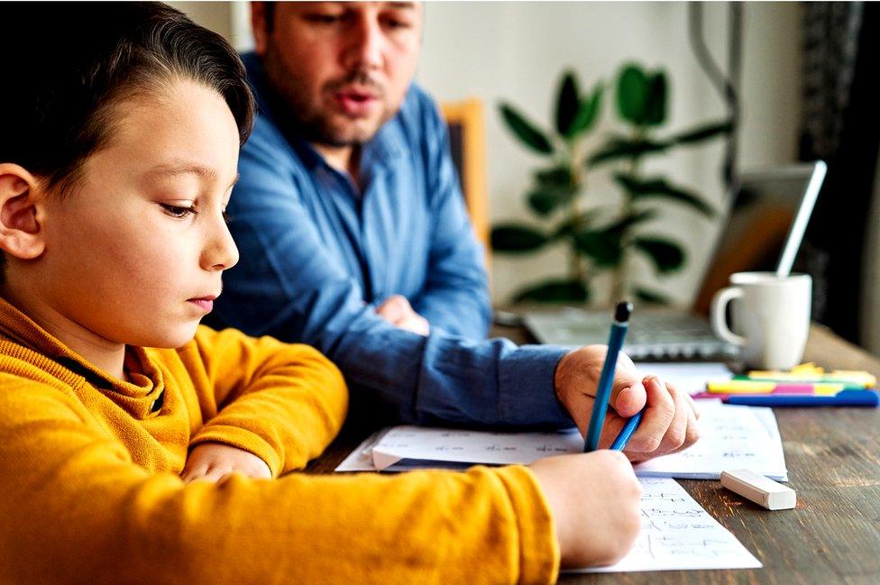 boy and dad doing homework together