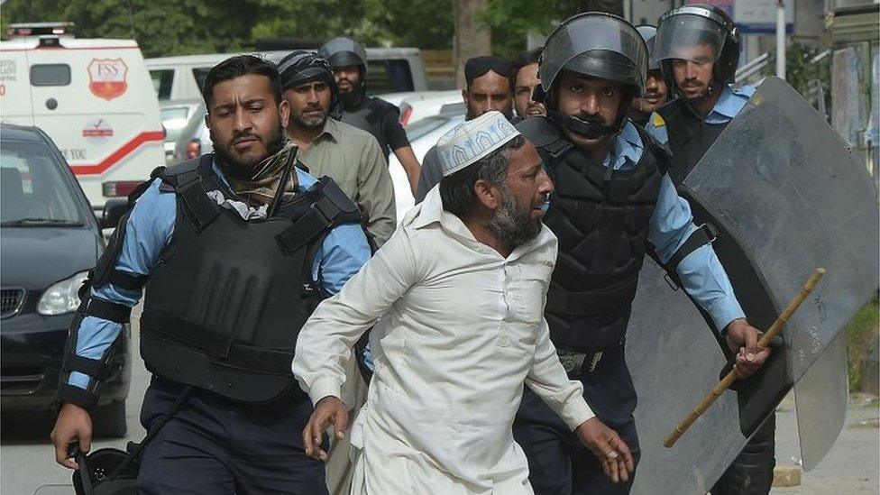 Pakistani riot policemen arrest a supporter of executed Islamist Mumtaz Qadri during an anti-government protest near the parliament building in Islamabad on March 28, 2016.