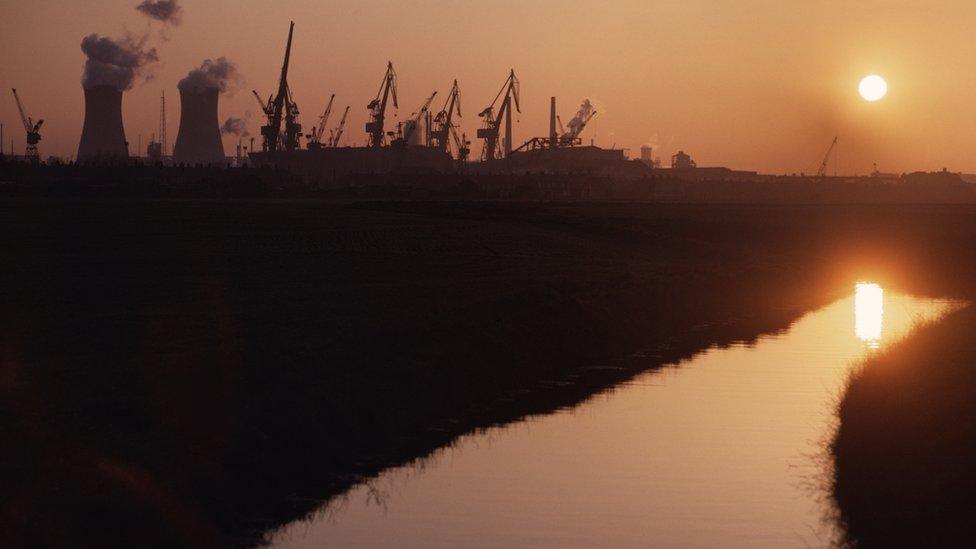 Sun setting over the river and industrial units