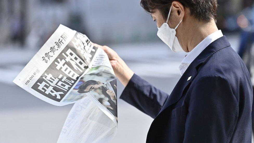 A man reads a special edition of a newspaper on the shooting of Shinzo Abe, July 2022