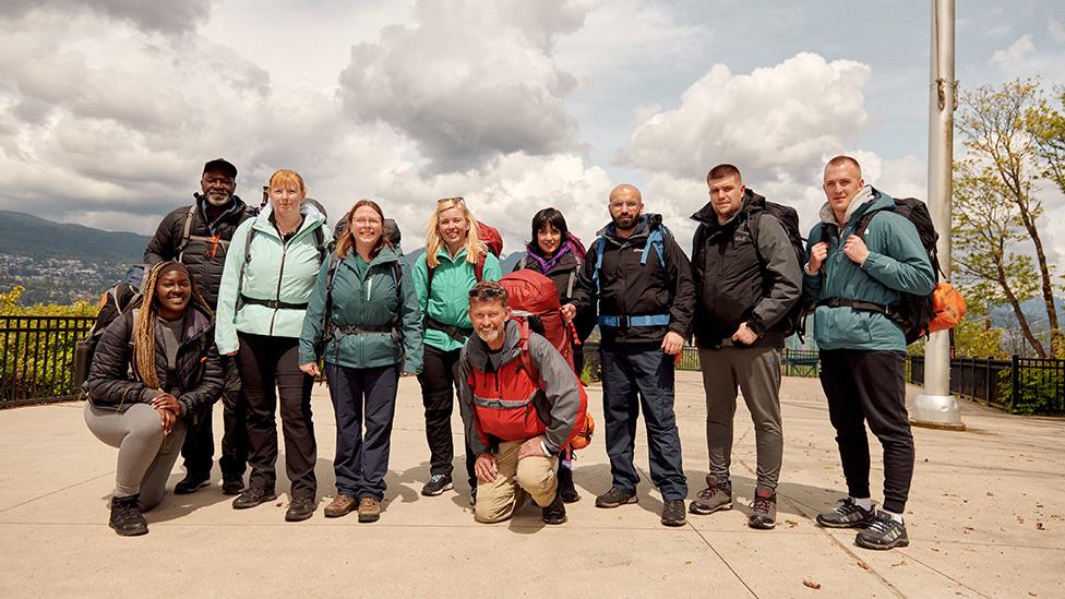 The cast of Race Across The World smiling at the camera, wearing coats and backpacks