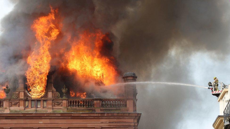 A firefighters hoses the fire at the Primark store in Belfast