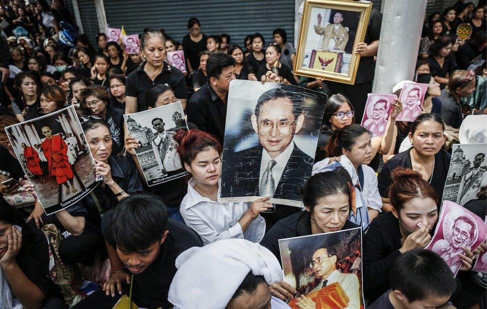 In this picture, Thai well-wishers hold pictures of King Bhumibol Adulyadej as they wait for the procession to move his body outside Siriraj Hospital in Bangkok, Thailand, on 14 October 2016.