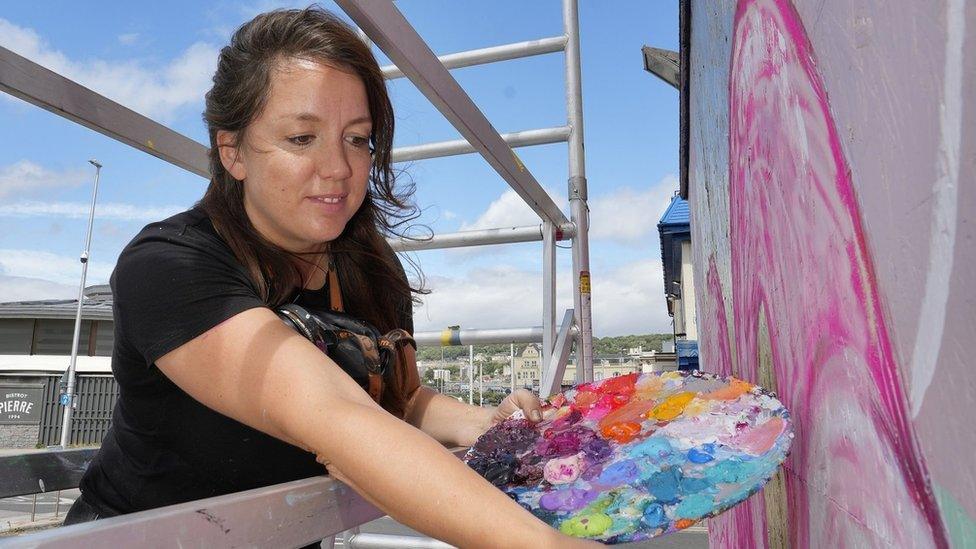 Street artist Sian Storey painting as part of Weston Wallz