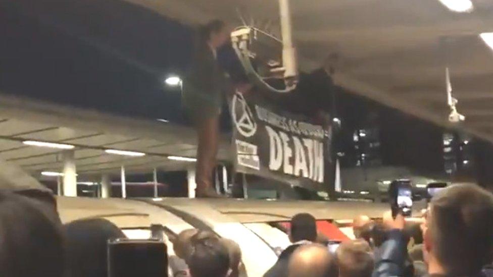 extinction rebellion protestors hold up the jubilee line at canning town station by standing on the train