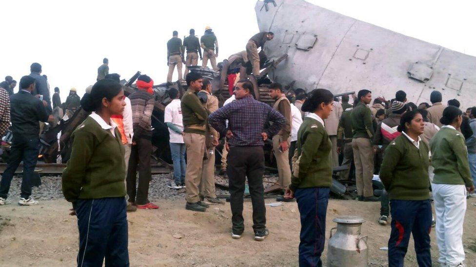 Women stand guard by one of the overturned carriages