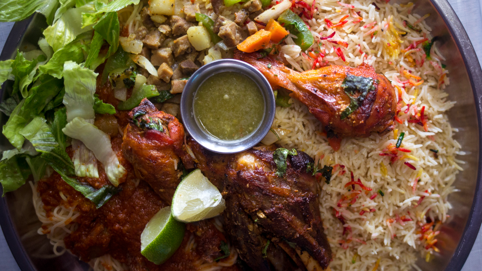 A platter for two with rice, pasta, hilib (lamb), chicken and beef suqaar at a Somali restaurant in Maine, the US