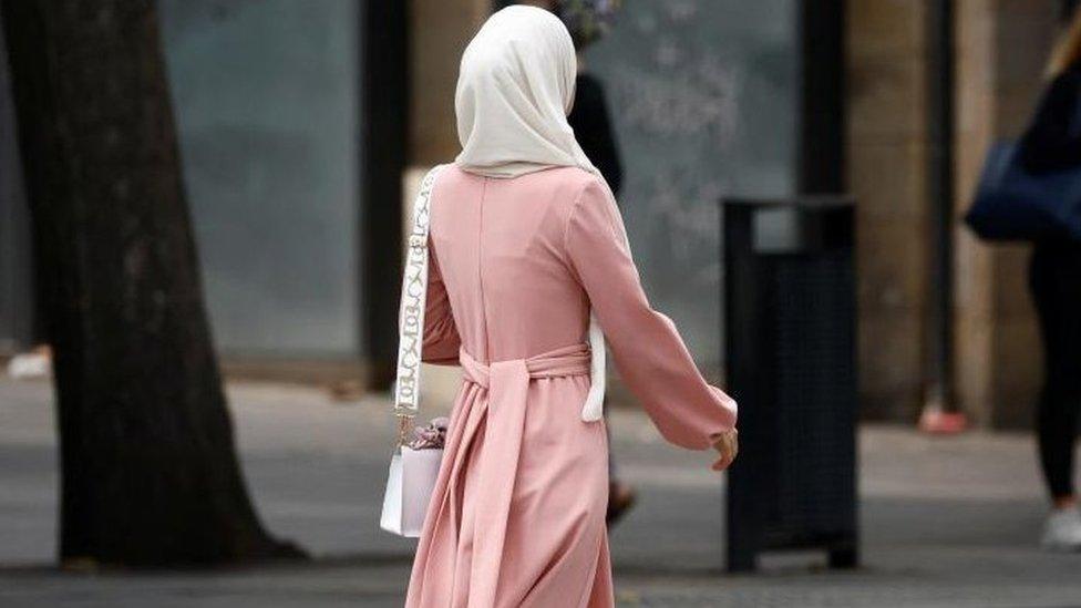 A Muslim woman, wearing the style of dress called an abaya, walks in a street in Nantes, France, August 29, 2023