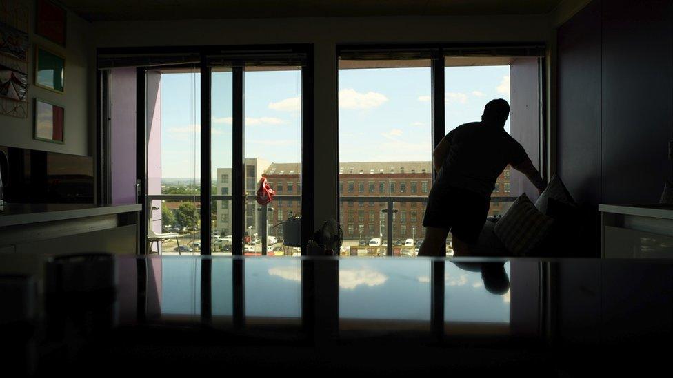 Woman silhouetted against glass French window