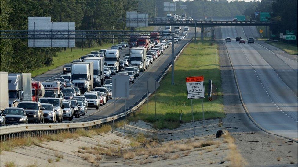 View of US highway showing bumper-to-bumper traffic on northbound lanes while southbound ones nearly empty