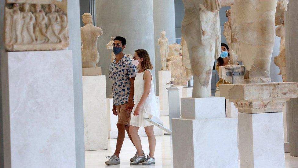 Tourists walking around the Acropolis Museum