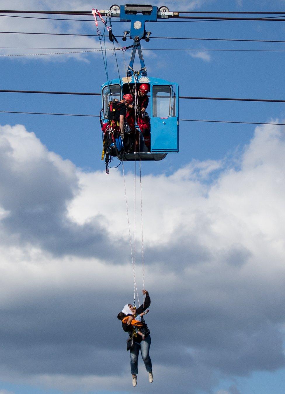 A mother and her child abseil from a gondola over the Rhine in Cologne, western Germany, 30 July 2017