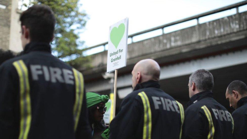 Firefighters with a United for Grenfell placard