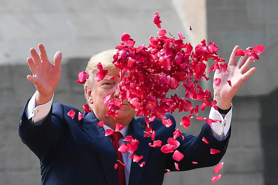 US President Donald Trump throws rose petals to pay tribute at Raj Ghat, the memorial for Indian independence icon Mahatma Gandhi, in New Delhi. 25 February 2020.