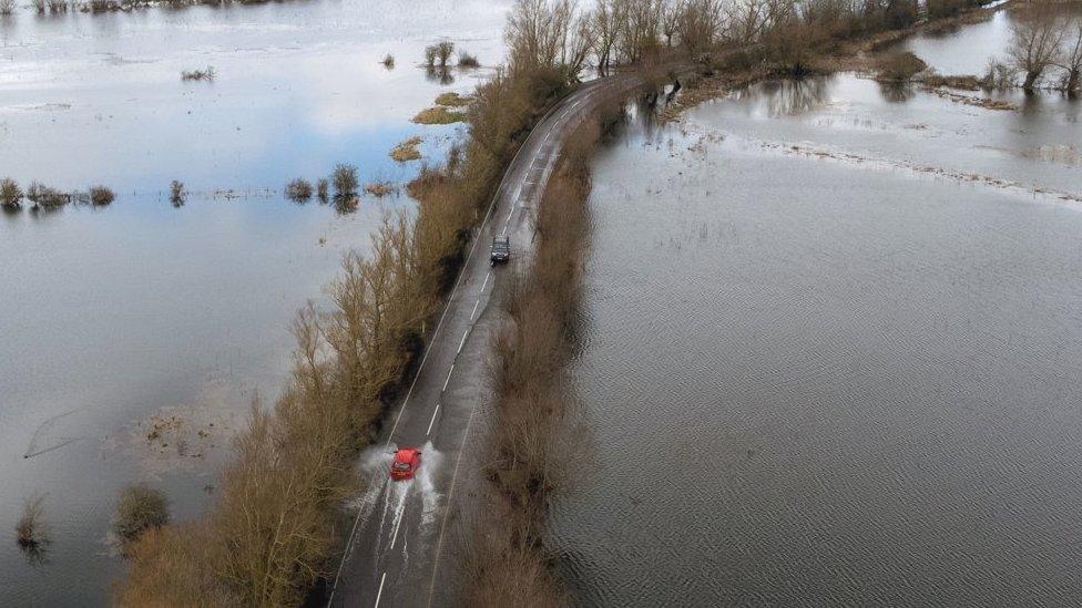 Drivers on the flooded A1101 in Norfolk on Sunday