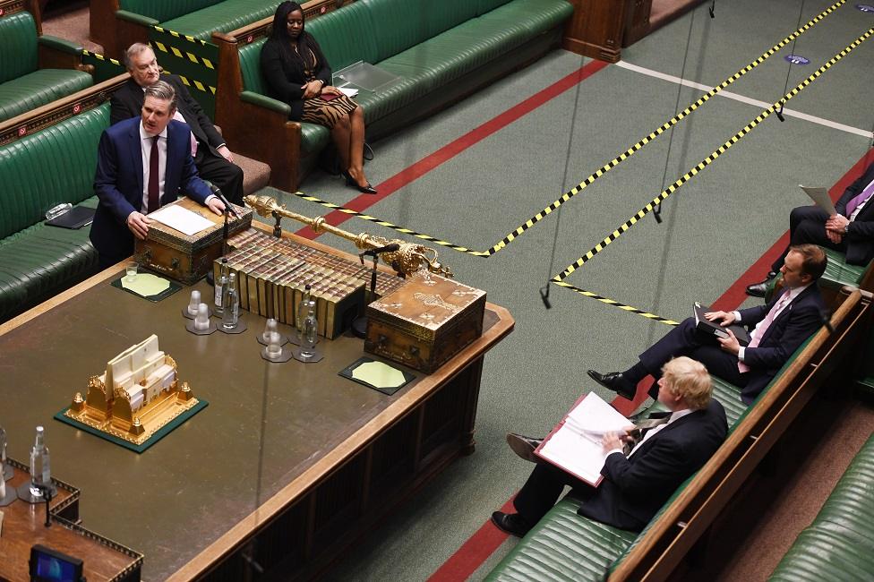 A handout photo made available by the UK Parliament shows Labour leader Keir Starmer (L) speaking as Prime Minister Boris Johnson (bottom R) listens during Prime Minister Questions at the House of Commons in London