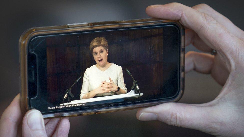 First Minister Nicola Sturgeon delivering an update statement is streamed on a smartphone