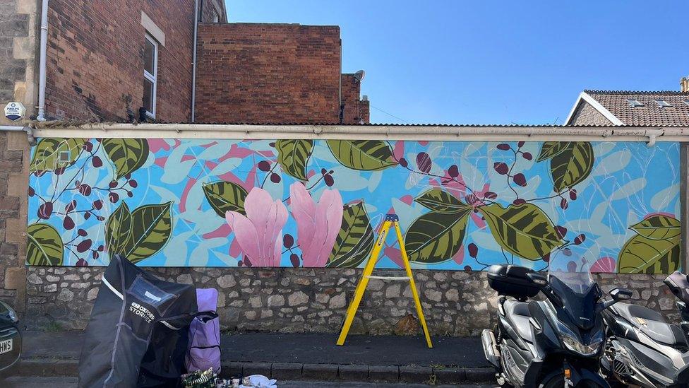 Pink flowers and leaves painted on a wall