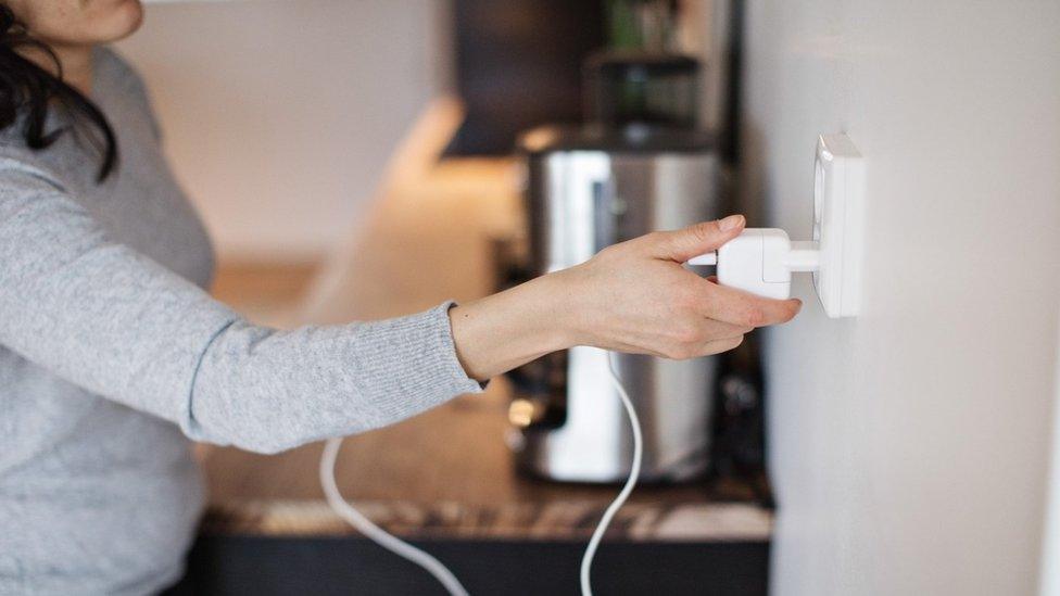 woman unplugging electrical device