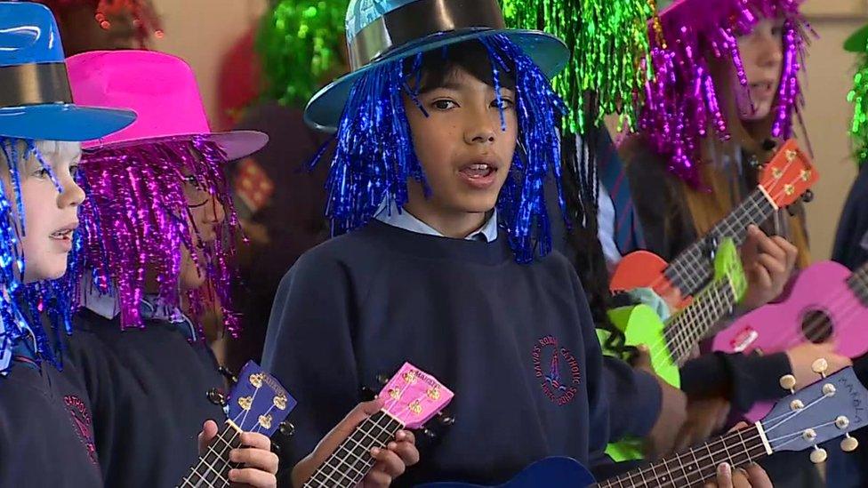 boy in hat playing ukulele