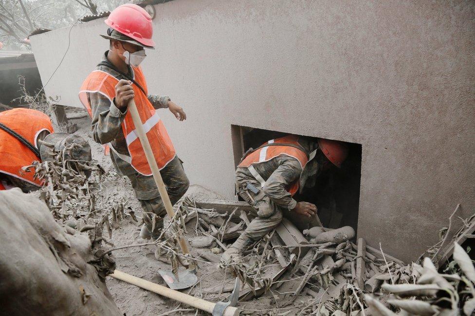 Soldiers inspect an area affected by the eruption of the Fuego volcano