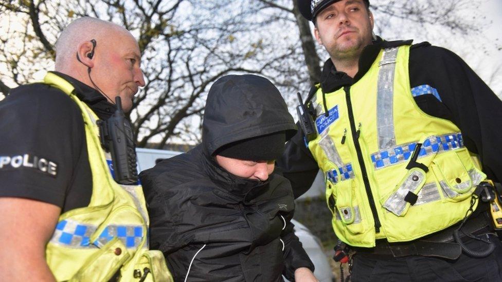 Paul Worthington with two police officers as he enters the inquest building